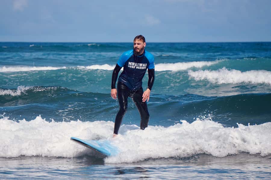 Auckland: Group Surfing Lesson with Muriwai Surf School - Learning to stand before you meet the waves