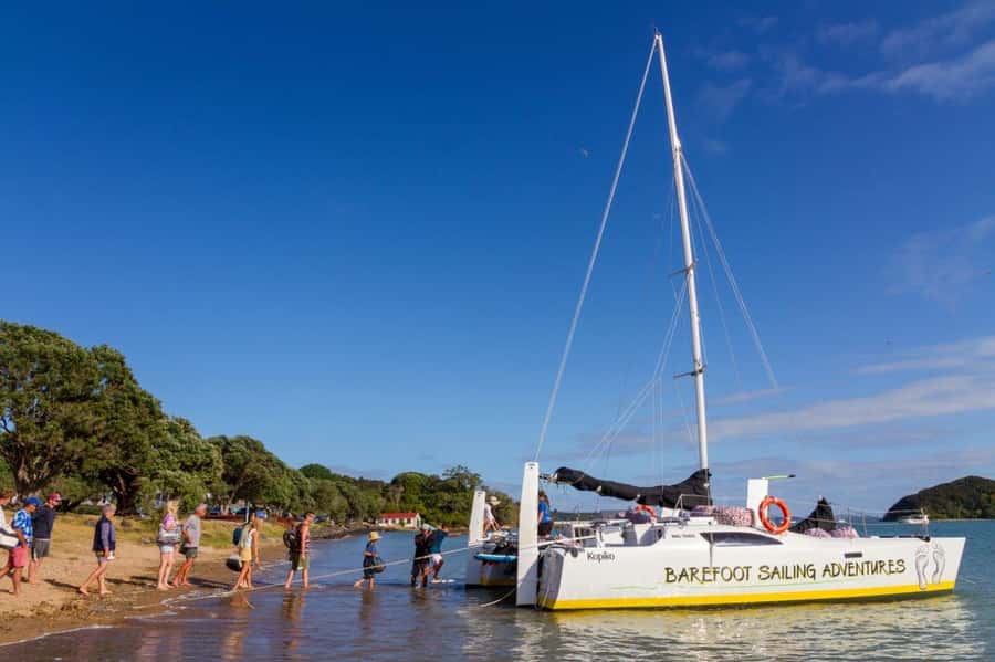 Bay of Islands 2-Hour Sundowner Evening Sailing Cruise - Boarding barefoot from Paihia Beach